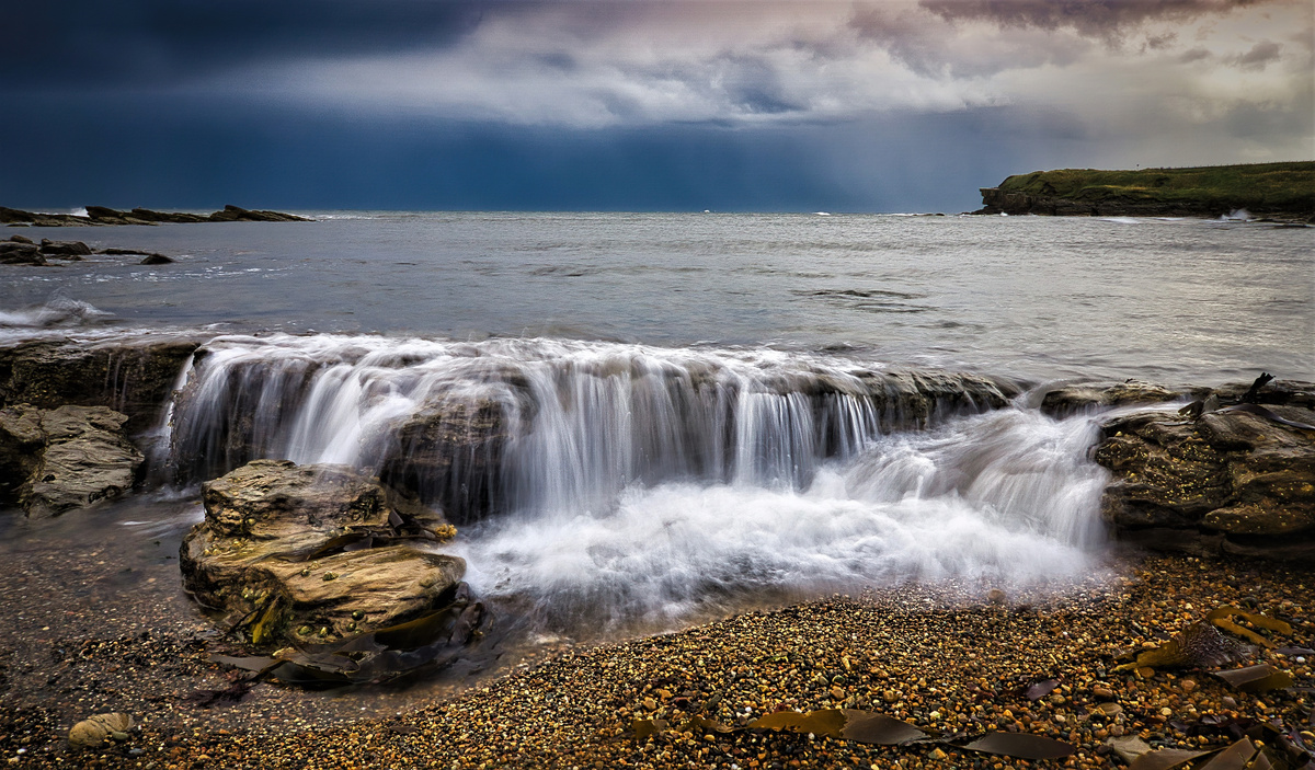 Sea Water Overflowing Rocks on Beach
